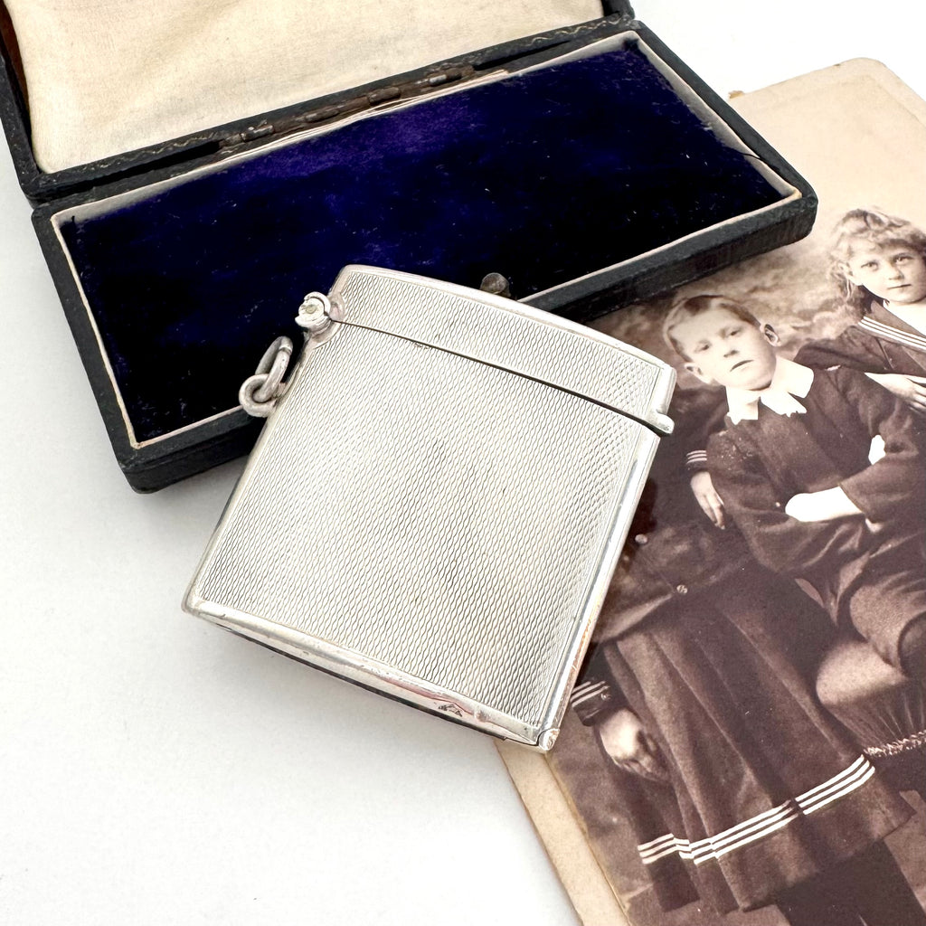 Vintage 1935 hallmarked vesta case made by G&SC Ltd of Regent St, London with a black box and vintage photo of children on a white background