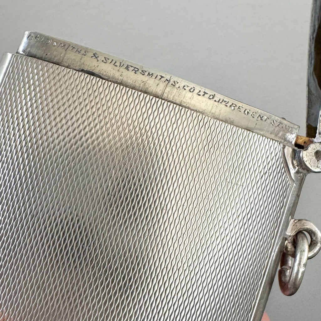 Close-up of a silver vesta case made by G&S C Ltd with engraved text on a gray background