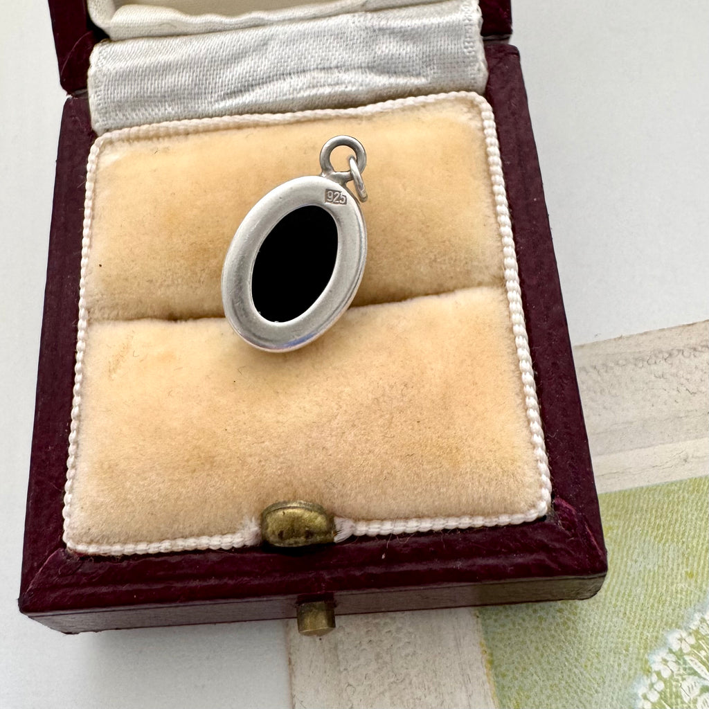 Silver pendant in a jewelry box on a light background