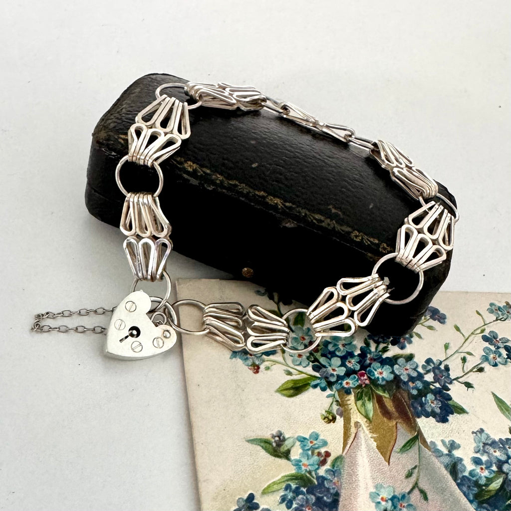 Silver bracelet with a heart charm on a floral background