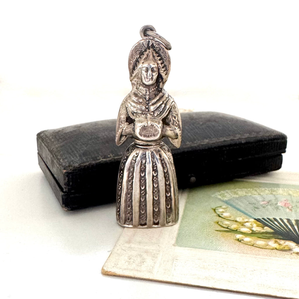 Vintage figural sterling silver needle cae necklace on an old jewellery box and with a vintage postcard