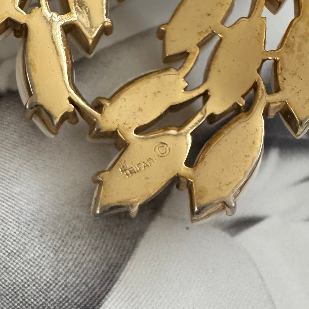 Close up of Trifari signature on a gold tone brooch