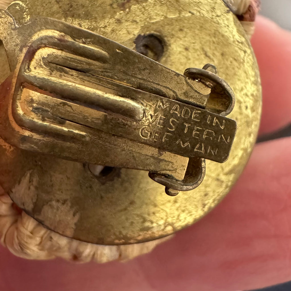 Close-up of vintage clip on earrings with 'Made in Western Germany' engraving.
