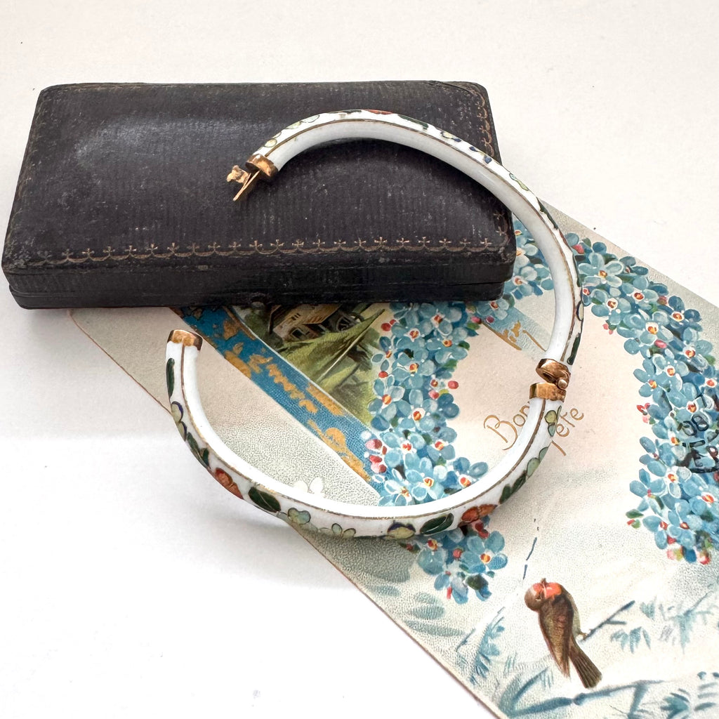 Decorative vintage cloisonne bracelet with floral patterns on a textured surface