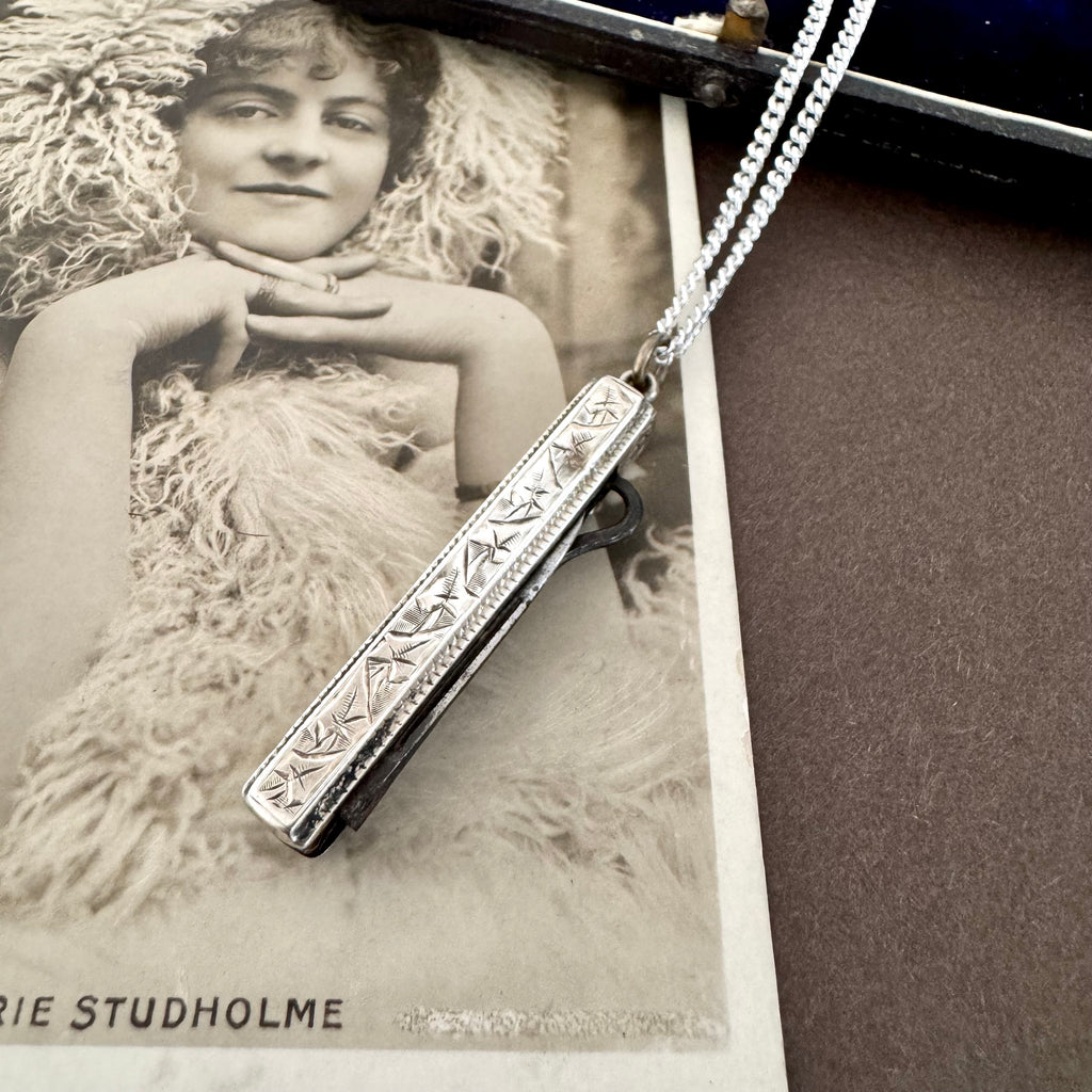 Vonk Jewellery antique 1885 button hook and pearl charm necklace on a brown background and with a vintage postcard and jewellery box