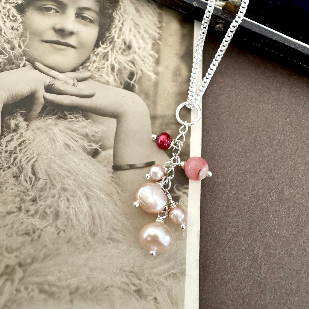 Vonk Jewellery antique 1885 button hook and pearl charm necklace on a brown background and with a vintage postcard and jewellery box