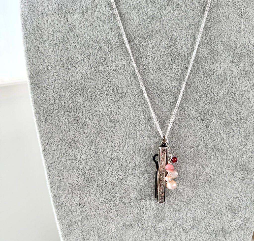 Vonk Jewellery antique 1885 button hook and pearl charm necklace on a grey velvet necklace display