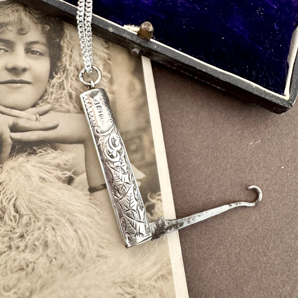Vonk Jewellery 1894 silver button hook and pearl and lapis charm necklace on a vintage postcard and vintage jewellery box