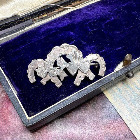 Vonk Jewellery sterling silver sweetheart brooch featuring horseshoes, hearts and flowers on a vintage jewellery box