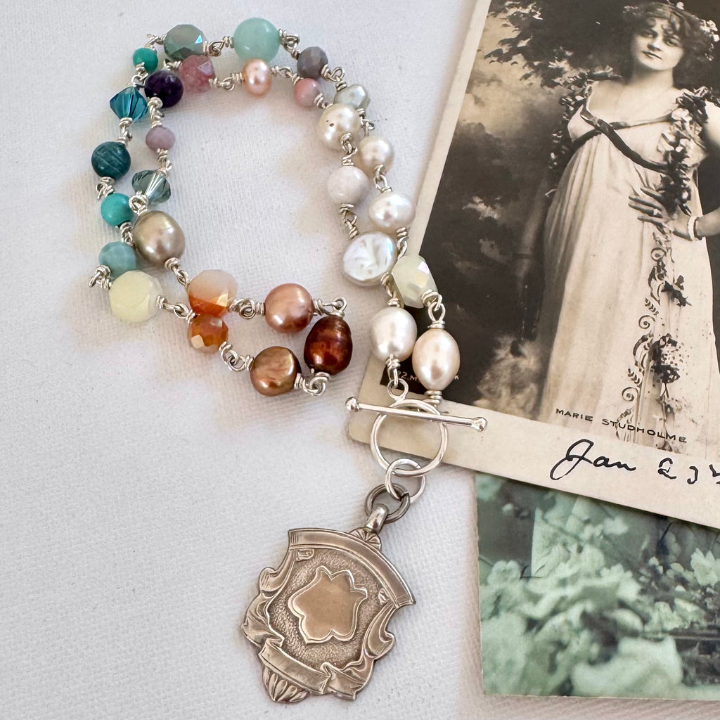 Vonk Jewellery 1935 watch fob, pearl and crystal necklace with a vintage postcard