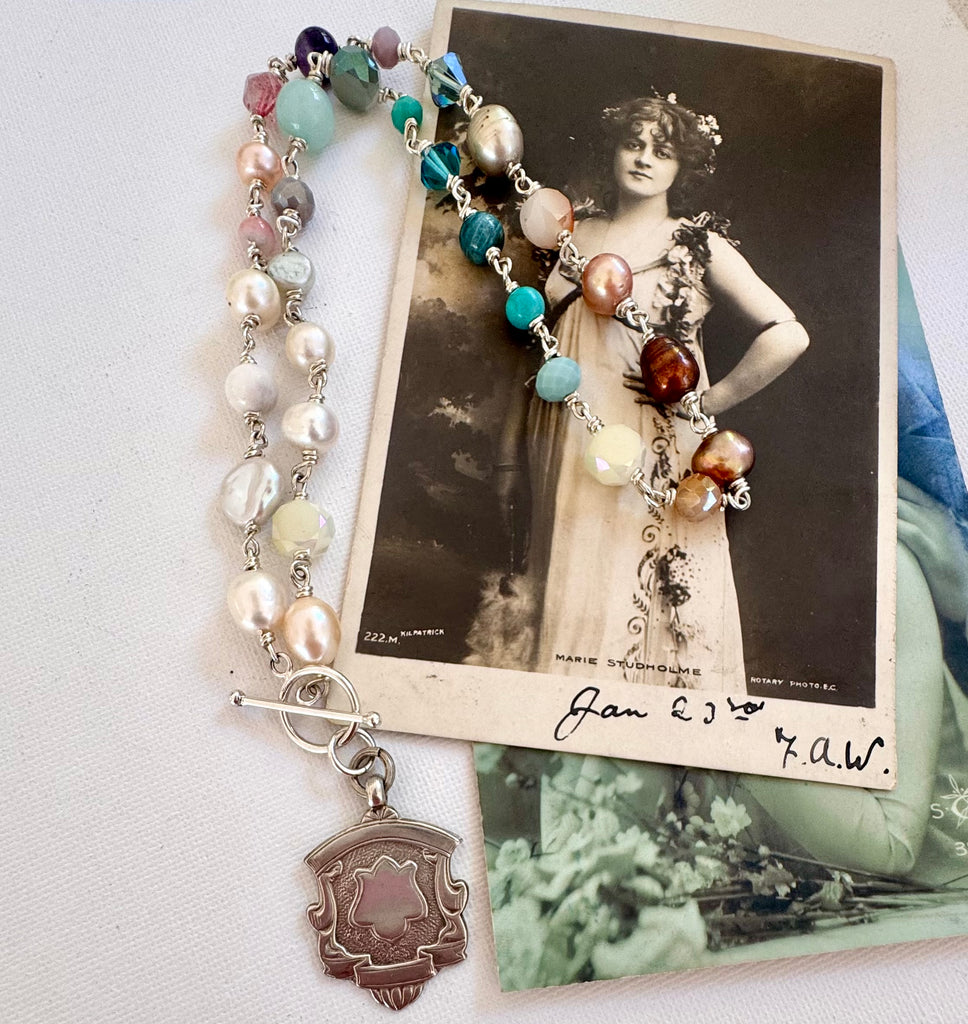 Vonk Jewellery 1935 watch fob, pearl and crystal necklace with a vintage postcard