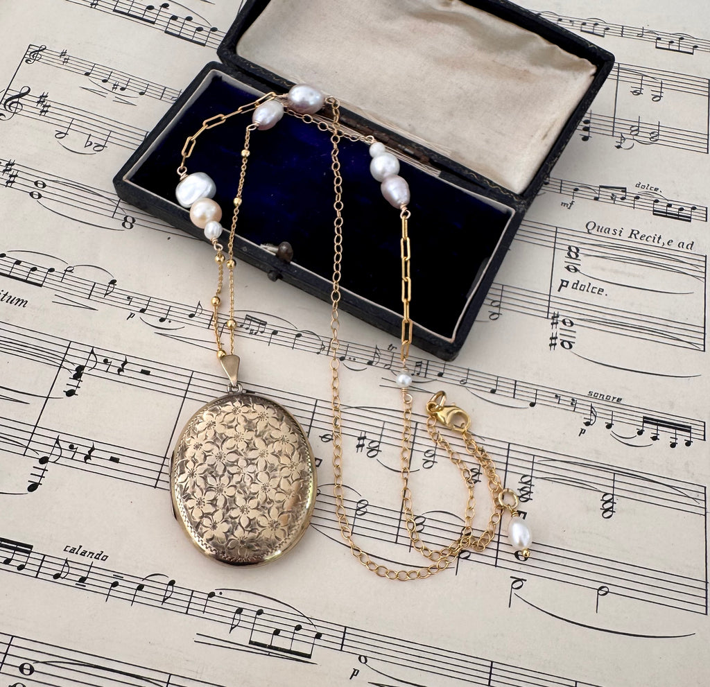 Vonk Jewellery vintage 1970 22ct gold plated locket necklace on a vintage jewellery box and music manuscript