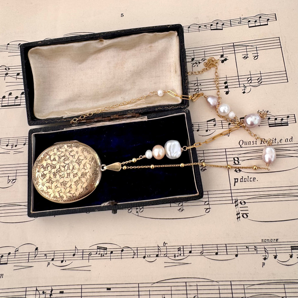 Vonk Jewellery vintage 1970 22ct gold plated locket necklace on a vintage jewellery box and music manuscript