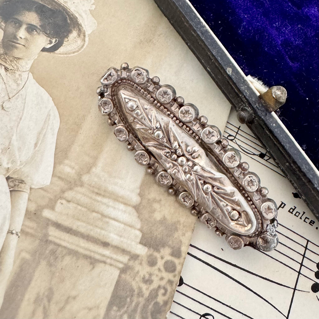 Vonk Jewellery Victorian 1889 silver brooch on a vintage postcard and with vintage sheet music