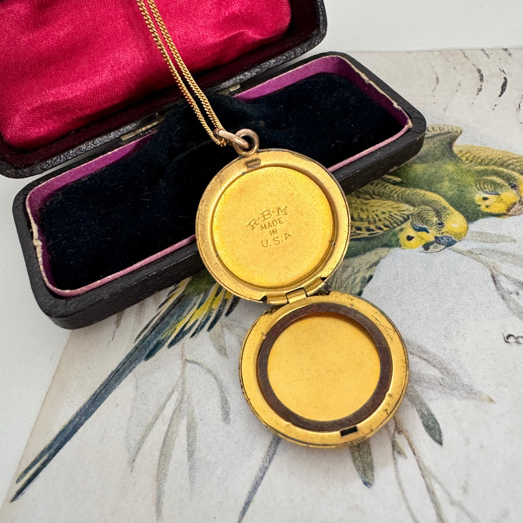 Vonk Jewellery antique R B M rolled gold locket on a vintage jewellery box and vintage postcard of love birds