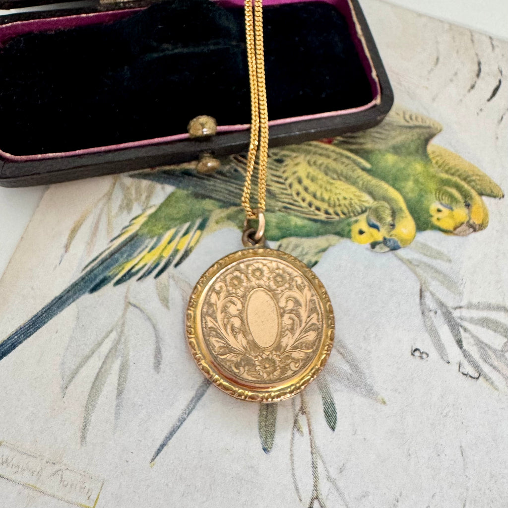 Vonk Jewellery antique R B M rolled gold locket on a vintage jewellery box and vintage postcard of love birds