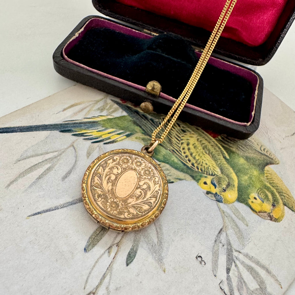 Vonk Jewellery antique R B M rolled gold locket on a vintage jewellery box and vintage postcard of love birds