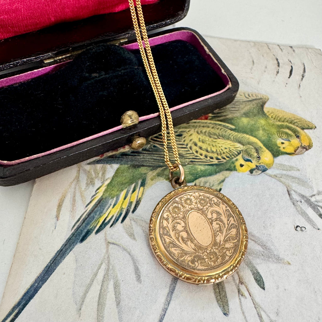 Vonk Jewellery antique R B M rolled gold locket on a vintage jewellery box and vintage postcard of love birds