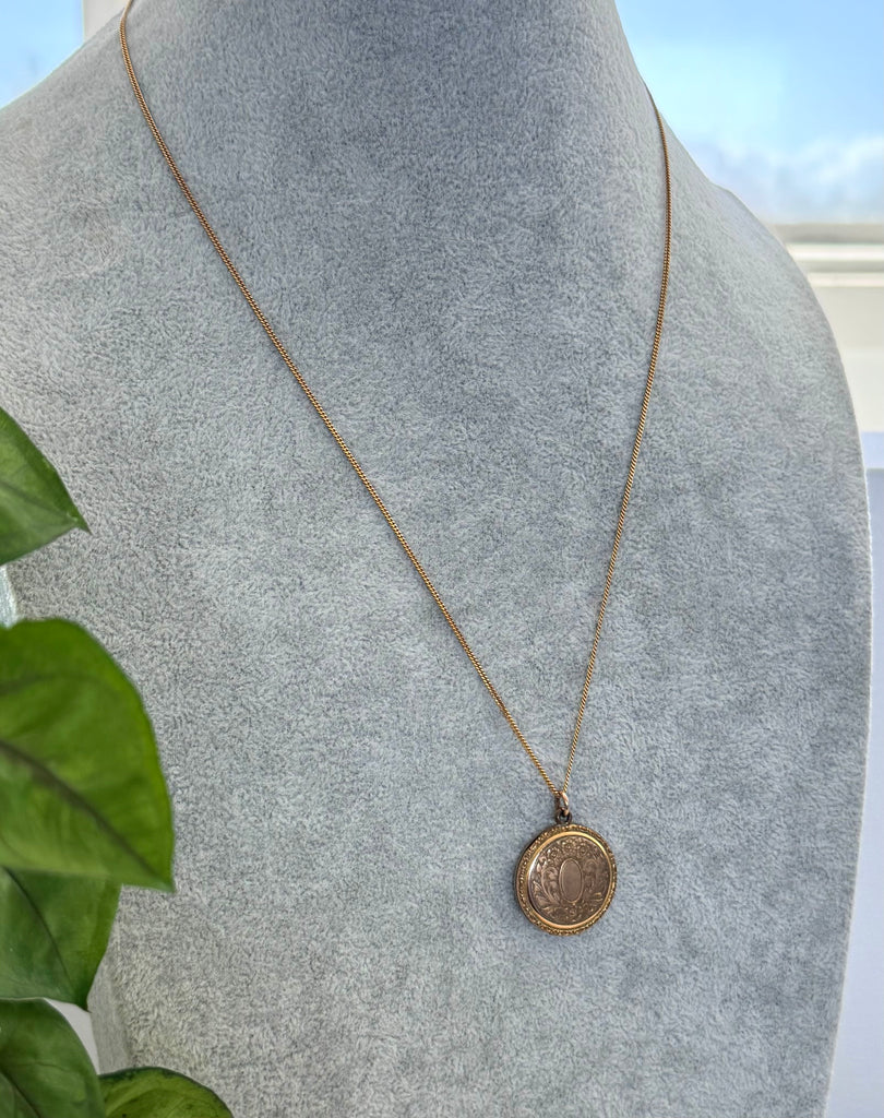 Vonk Jewellery antique R B M rolled gold locket on a grey jewellery display neck