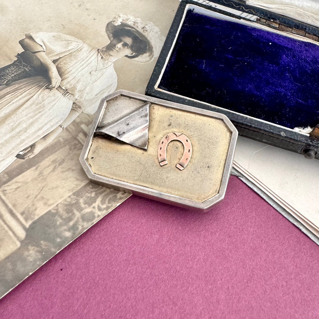 Vonk Jewellery antique silver horseshoe locket brooch on a vintage postcard, vintage sheet music and a vintage jewellery box