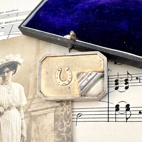 Vonk Jewellery antique silver horseshoe locket brooch on a vintage postcard, vintage sheet music and a vintage jewellery box