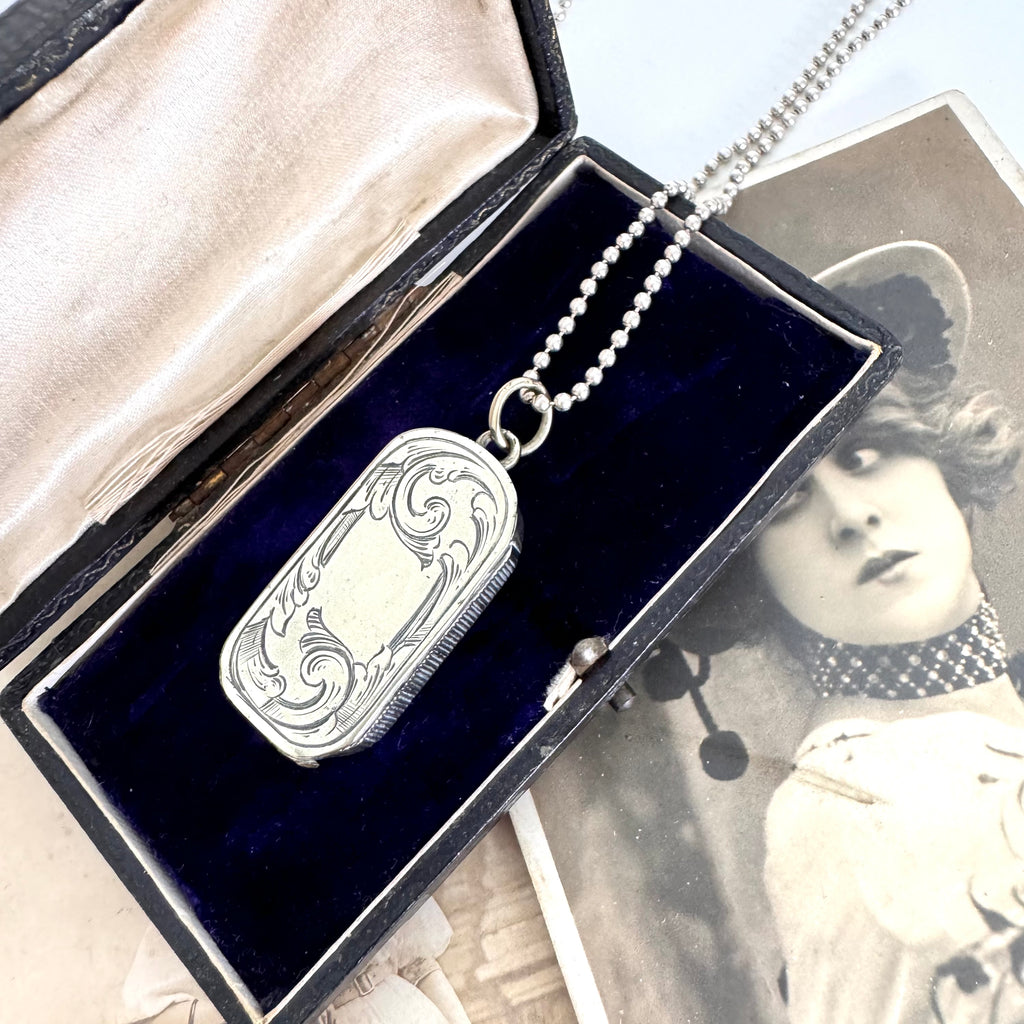 Vonk Jewellery antique vesta case necklace on a vintage jewellery box and with a vintage postcard of a woman.