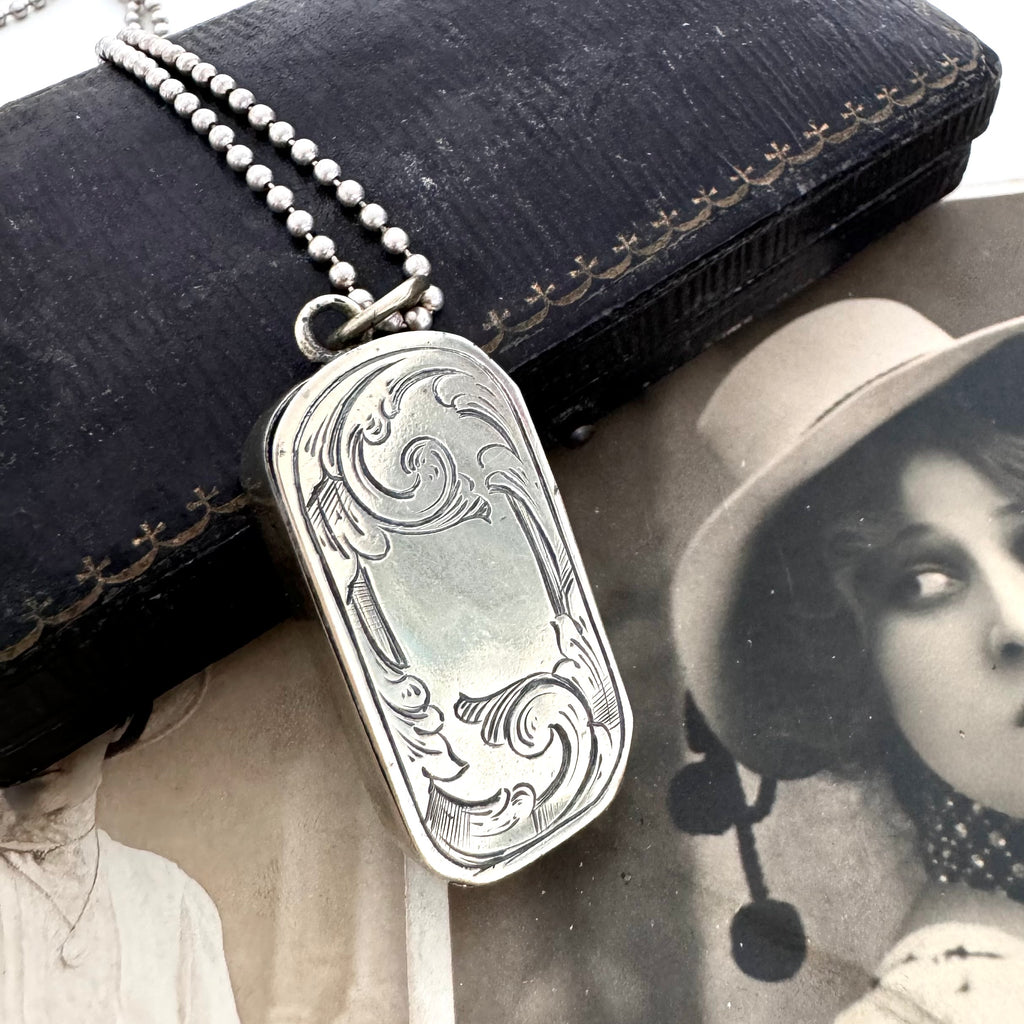 Vonk Jewellery antique vesta case necklace on a vintage jewellery box and with a vintage postcard of a woman.