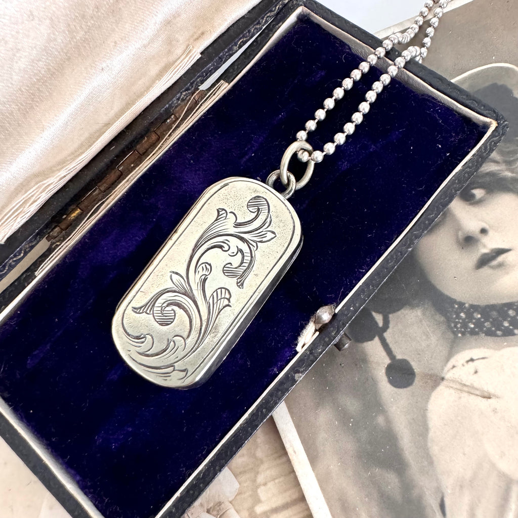 Vonk Jewellery antique vesta case necklace on a vintage jewellery box and with a vintage postcard of a woman.