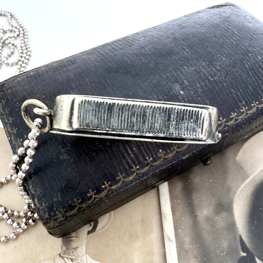 Vonk Jewellery antique vesta case necklace on a vintage jewellery box and with a vintage postcard of a woman.