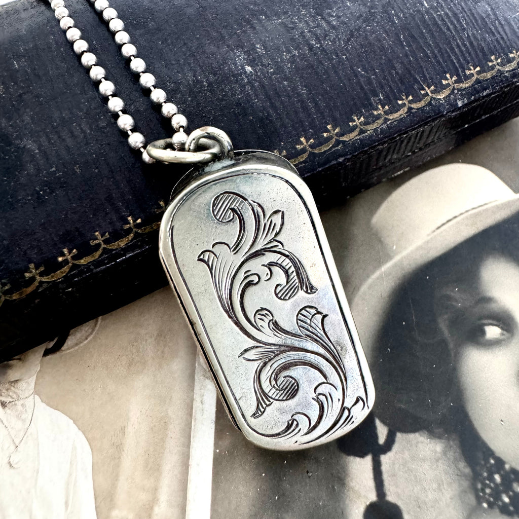 Vonk Jewellery antique vesta case necklace on a vintage jewellery box and with a vintage postcard of a woman.