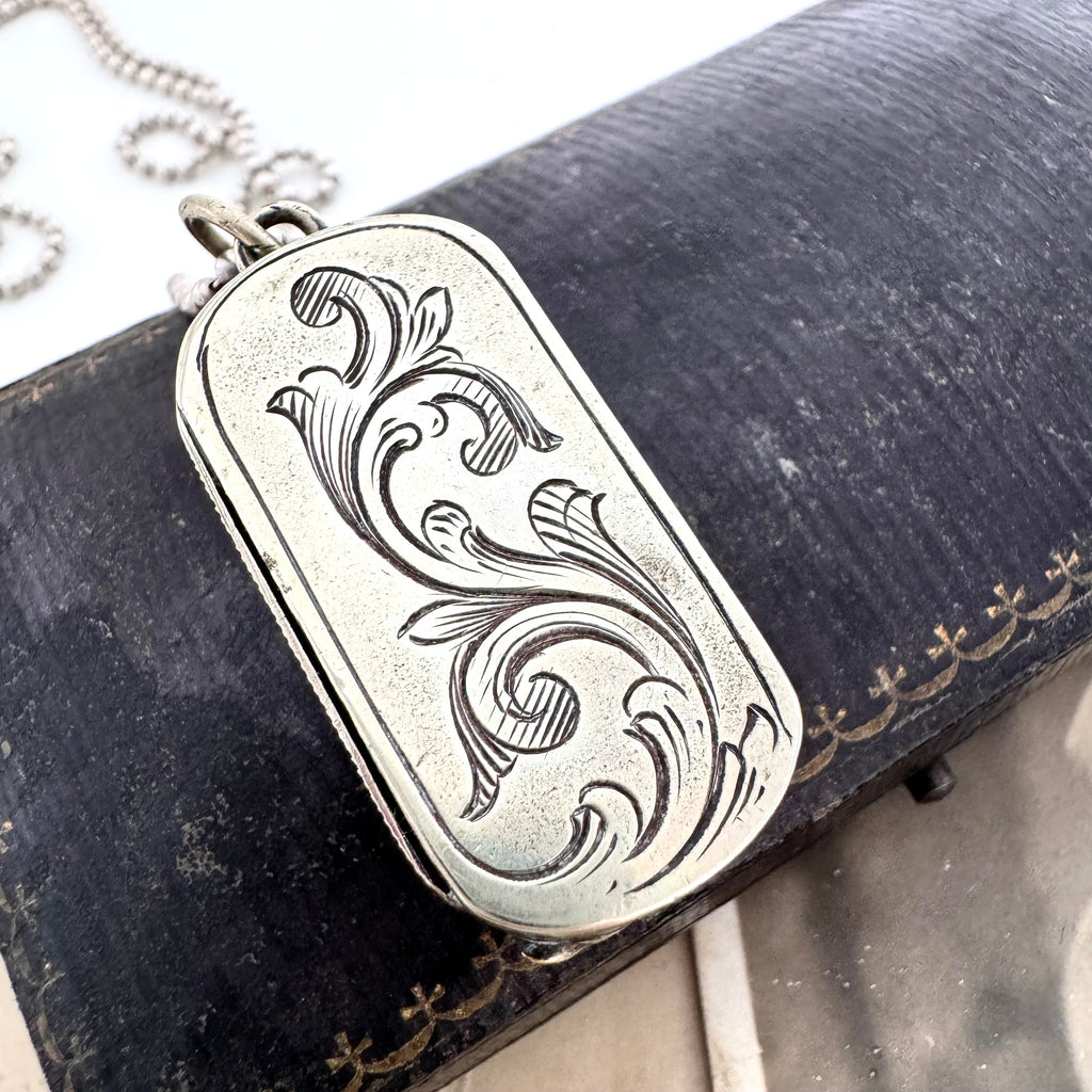 Vonk Jewellery antique vesta case necklace on a vintage jewellery box and with a vintage postcard of a woman.