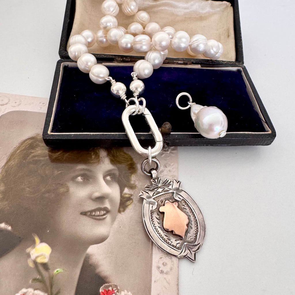 Vonk Jewellery 1931 watch fob and pearl necklace on a vintage postcard and vintage jewellery box