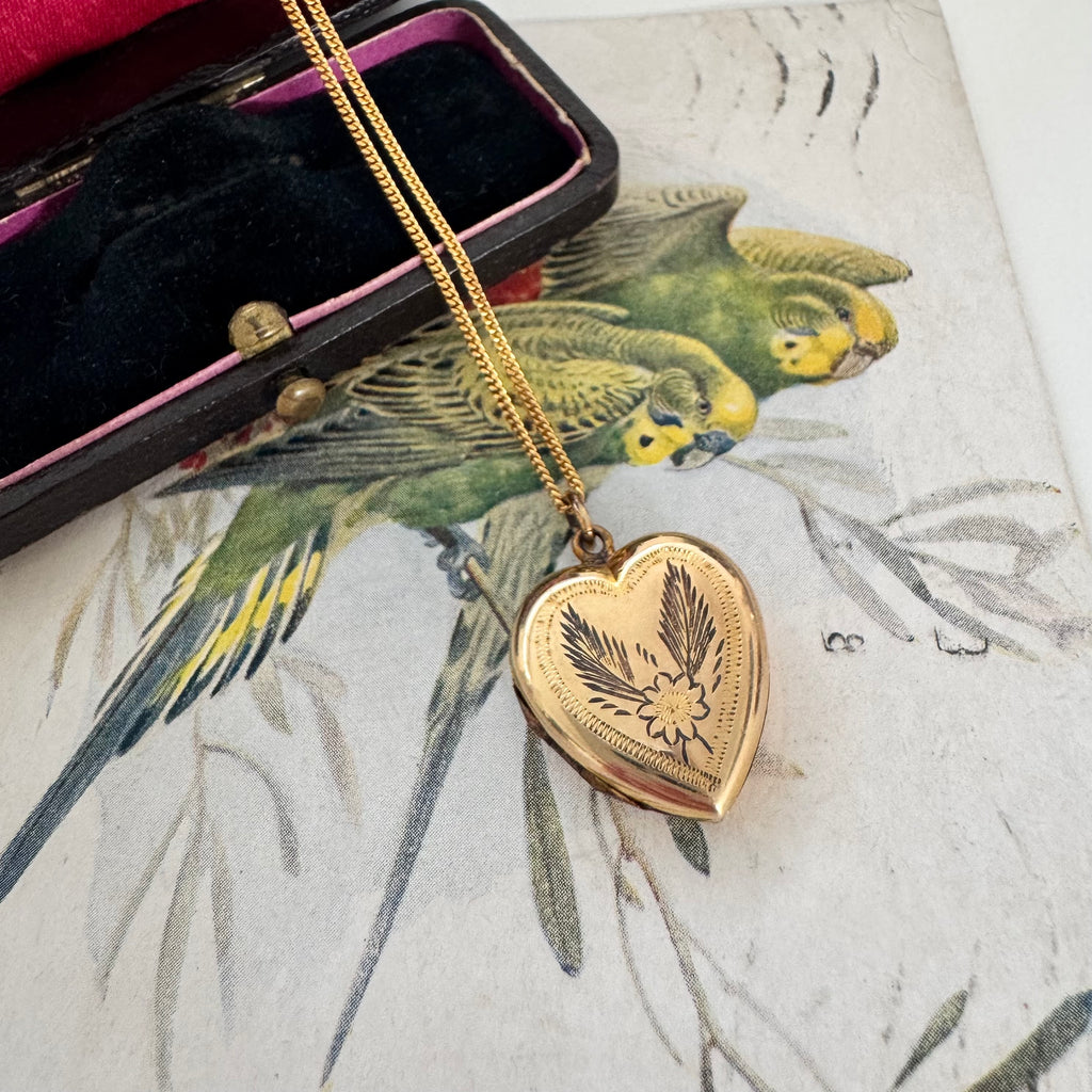 Vonk Jewellery rolled gold vintage heart locket on a vintage jewellery box and vintage postcard of love birds.