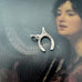 Vonk Jewellery silver vintage lucky wishbone charm on a picture of a woman playing a harp