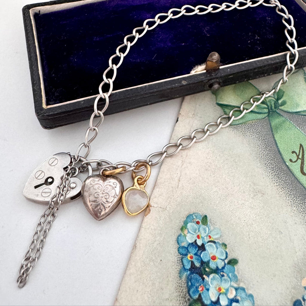 Vonk Jewellery vintage sterling silver heart clasp bracelet with a vintage charm and moonstone charm on a vintage postcard and jewellery box