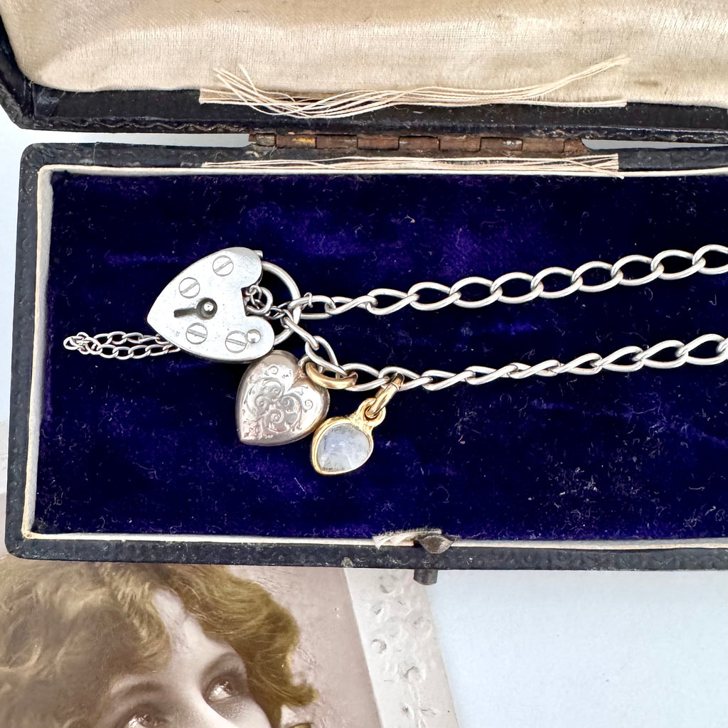 Vonk Jewellery vintage sterling silver heart clasp bracelet with a vintage charm and moonstone charm on a vintage postcard and jewellery box