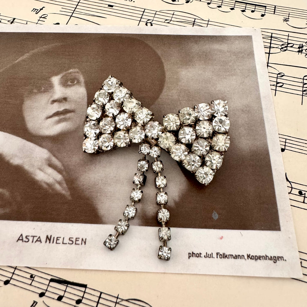 Vonk Jewellery vintage 1950's rhinestone bow brooch on a vintage postcard and vintage sheet music