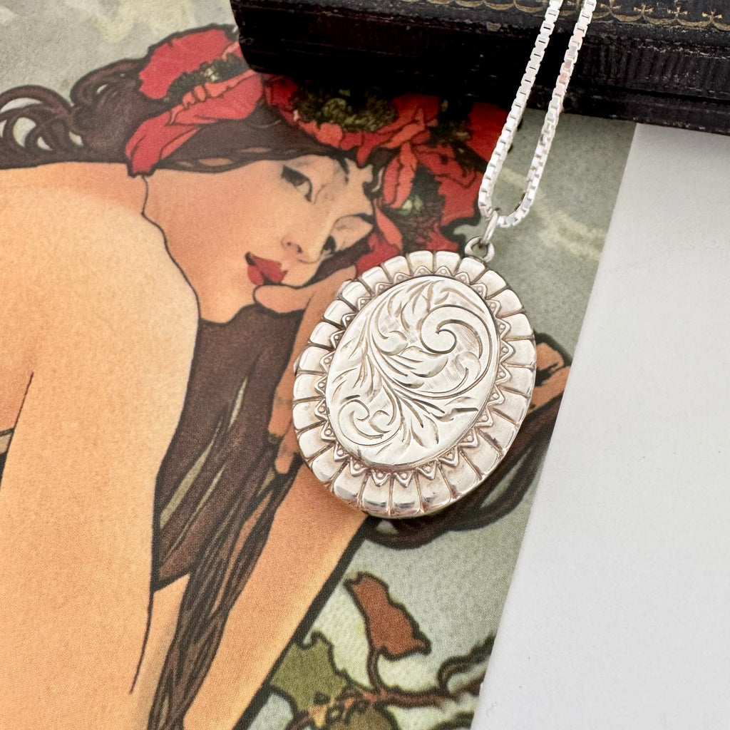 Vonk Jewellery 1977 sterling silver engraved locket on a vintage jewellery box and with a card of a woman with red flowers in her hair