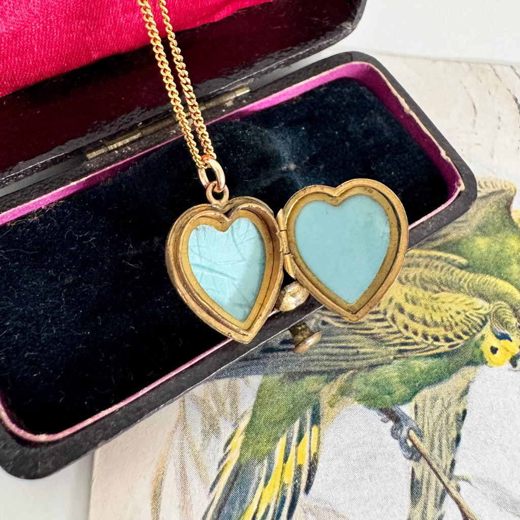 Vonk Jewellery rolled gold pearl and green onyx charm necklace on a vintage jewellery box and with a vintage postcard of love birds