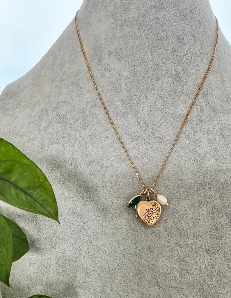 Vonk Jewellery rolled gold pearl and green onyx charm necklace on a grey necklace display neck
