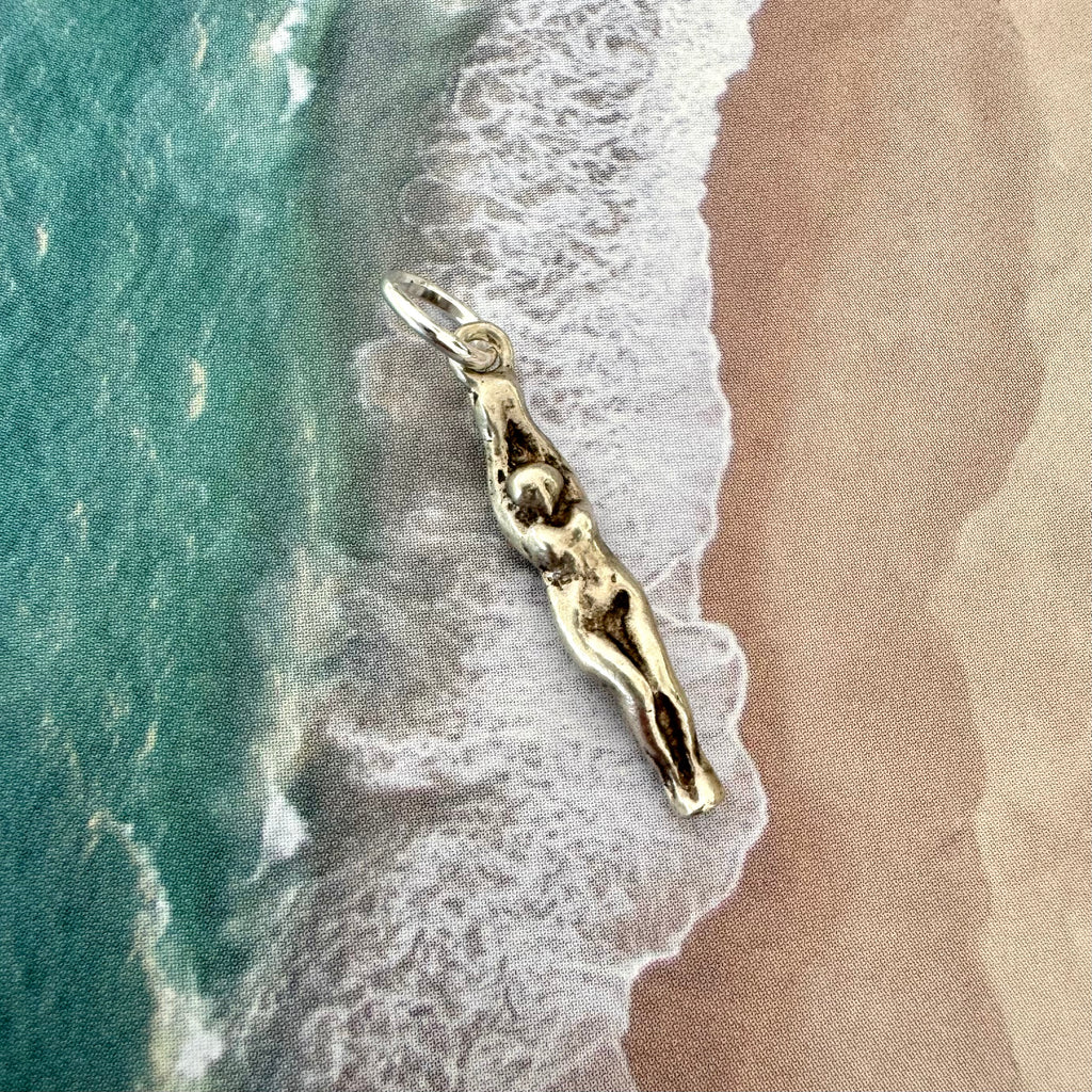 Vonk Jewellery vintage female swimmer or diver sterling silver charm on an image of the sand and sea