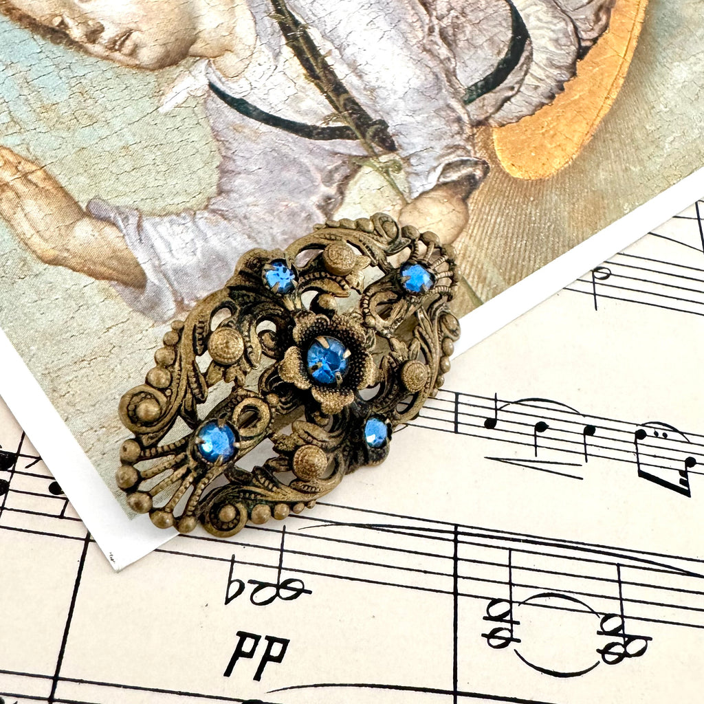 Vonk Jewellery antique made in Czechoslovakia blue stone brooch on a postcard of an angel and vintage sheet music
