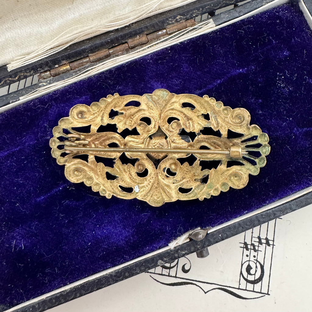 Back of Vonk Jewellery antique made in Czechoslovakia blue stone brooch on a vintage jewellery box and vintage sheet music
