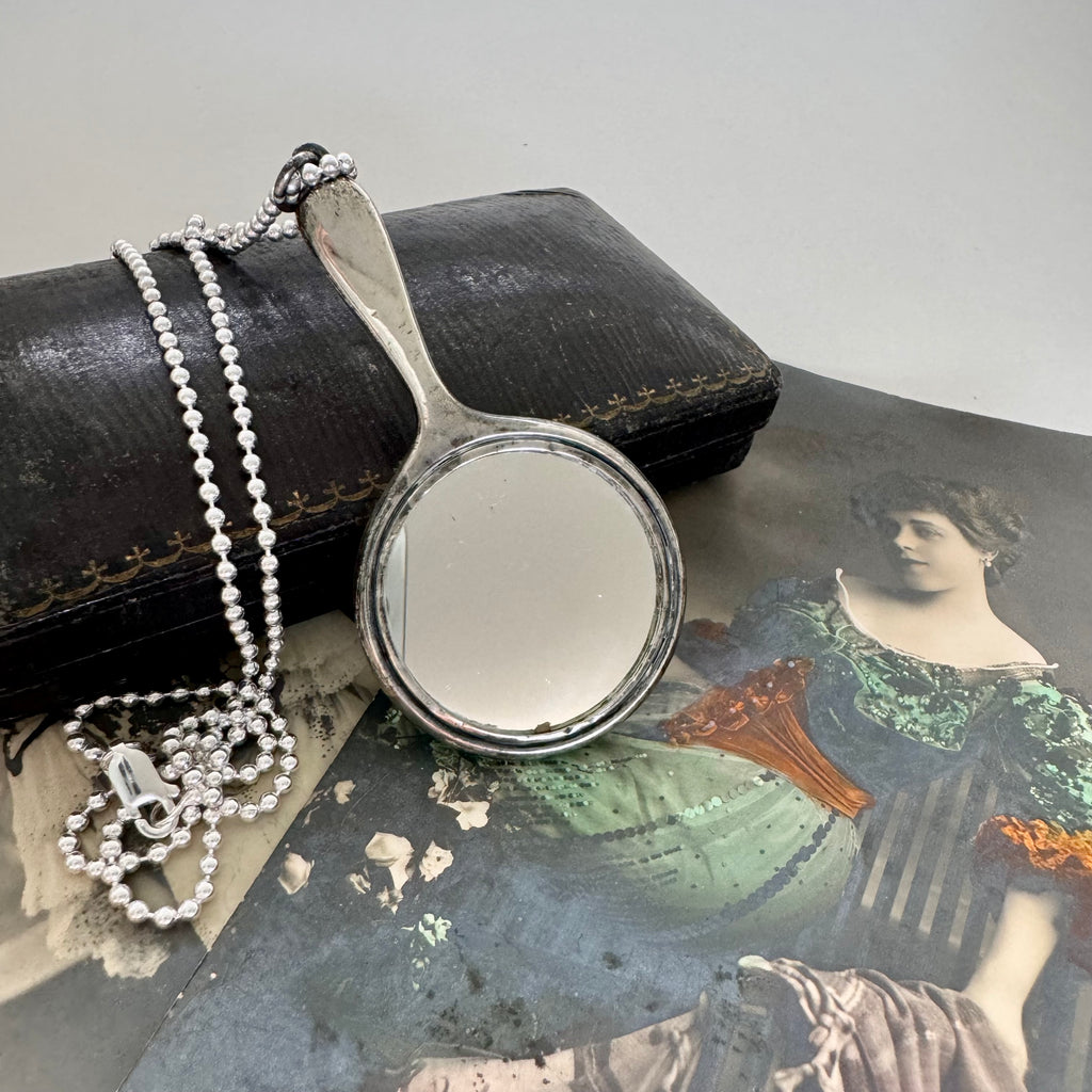 Vonk jewellery antique sterling silver hand mirror necklace on an antique box and with vintage postcards of a woman