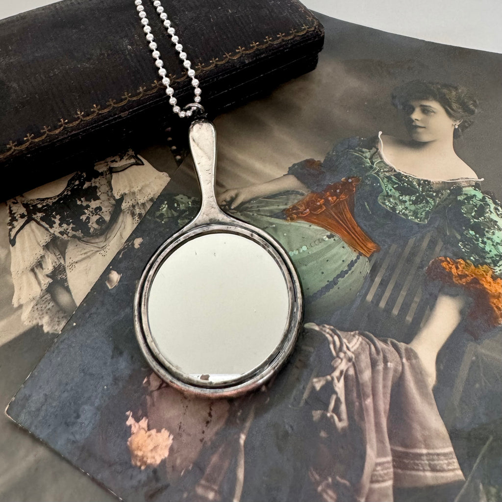 Vonk jewellery antique sterling silver hand mirror necklace on an antique box and with vintage postcards of a woman