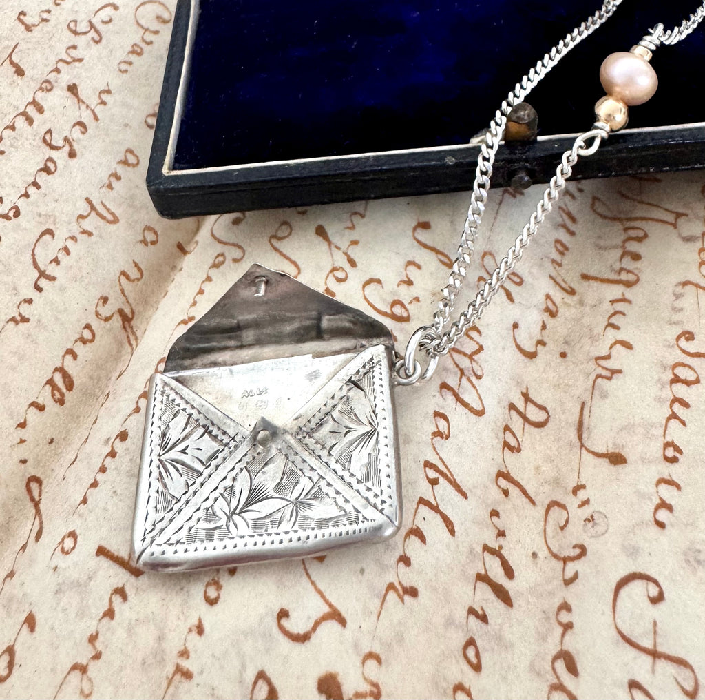 Vonk Jewellery 1905 sterling silver stamp necklace on an old manuscript and with a vintage jewellery box