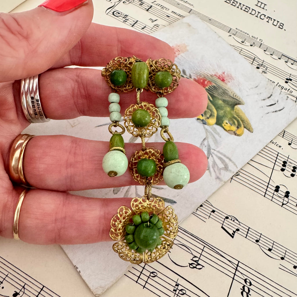 Vonk jewellery Made In Germany vintage gold tone and green bead dangle brooch on a vintage postcard and vintage sheet music