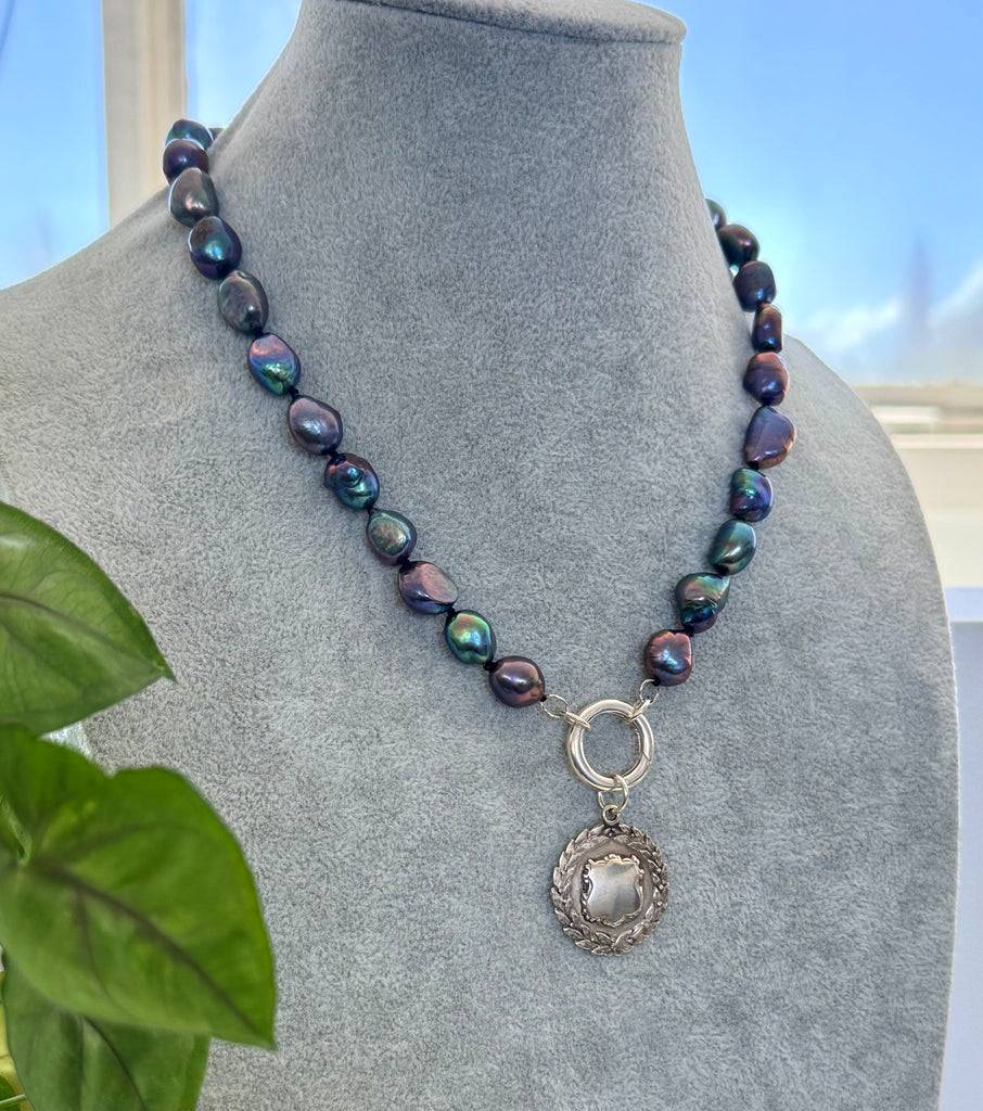 Vonk Jewellery peacock pearl and vintage silver watch fob necklace on a jewellery display neck