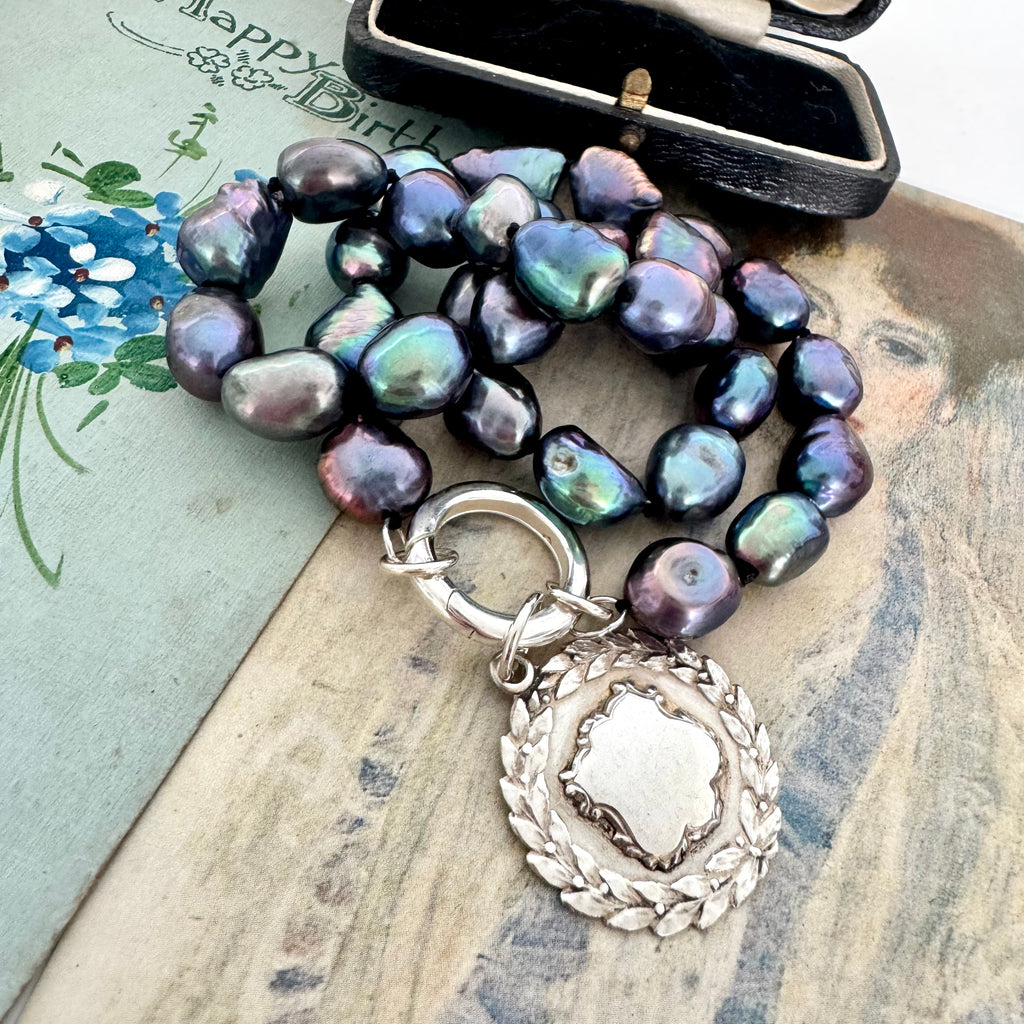 Vonk Jewellery peacock pearl and vintage silver watch fob necklace on 2 vintage postcards and with a vintage jewellery box