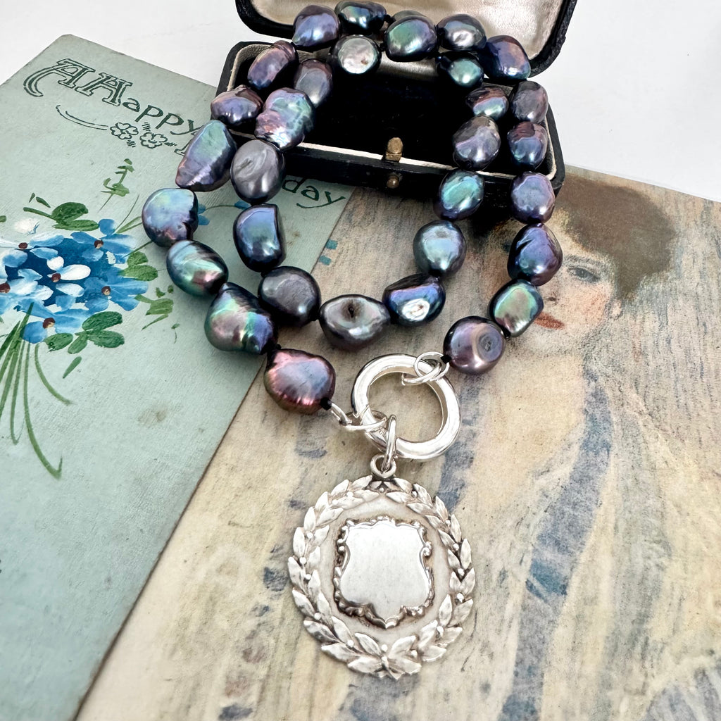 Vonk Jewellery peacock pearl and vintage silver watch fob necklace on 2 vintage postcards and with a vintage jewellery box